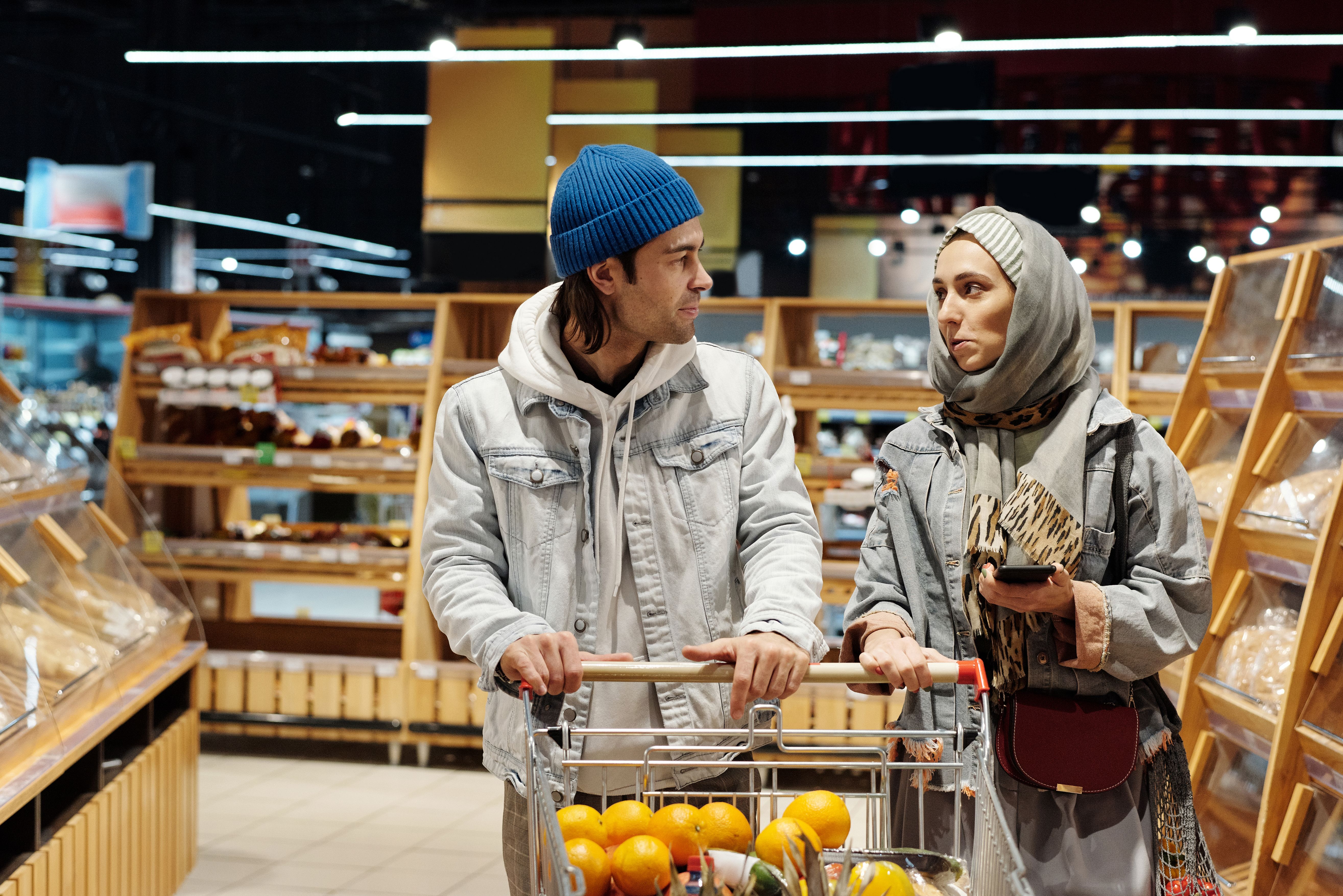 A diverse couple shopping for groceries in a supermarket aisle
