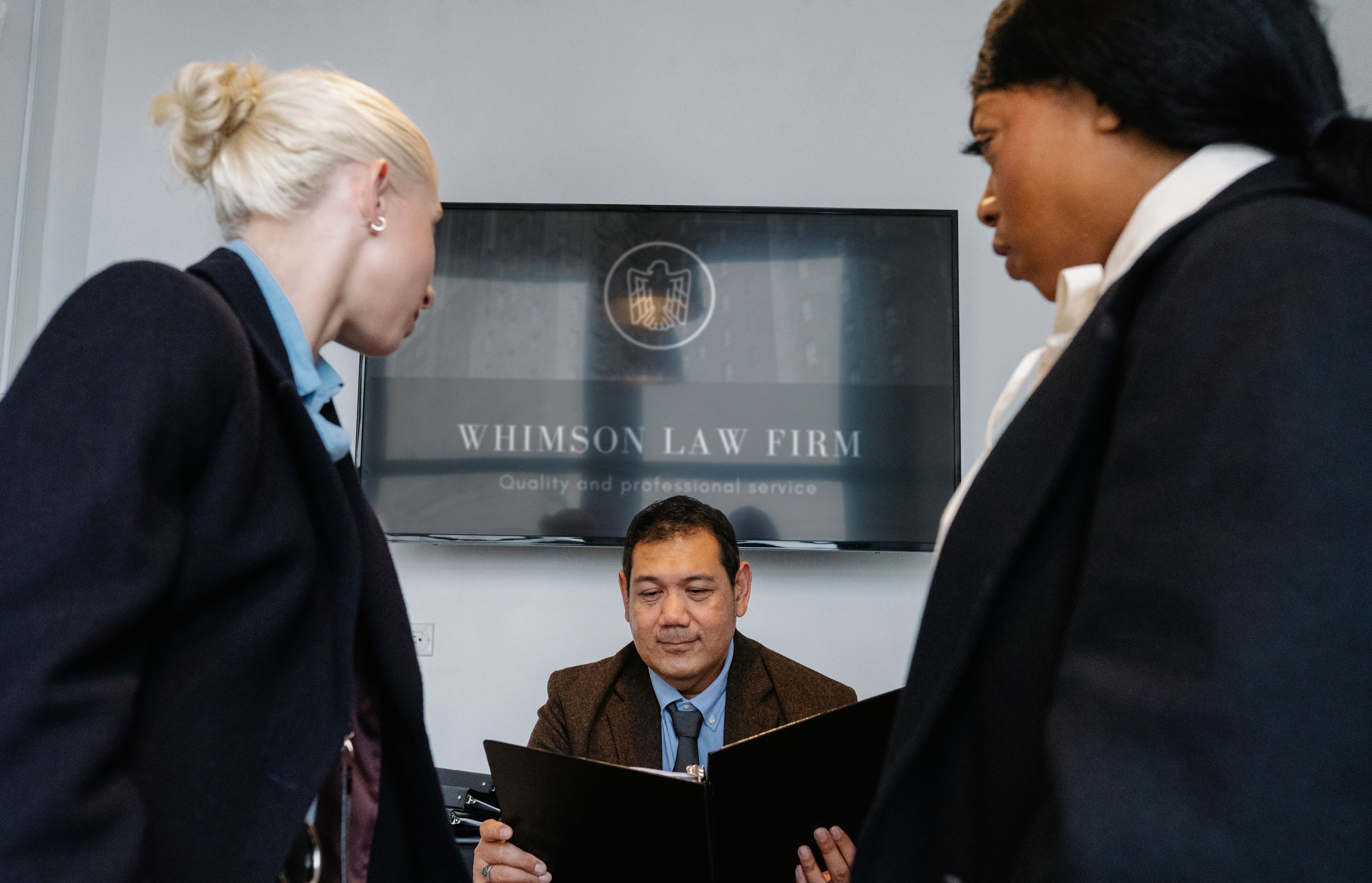 Diverse colleagues gathering in a law firm conference hall discussing a cross-border contract together