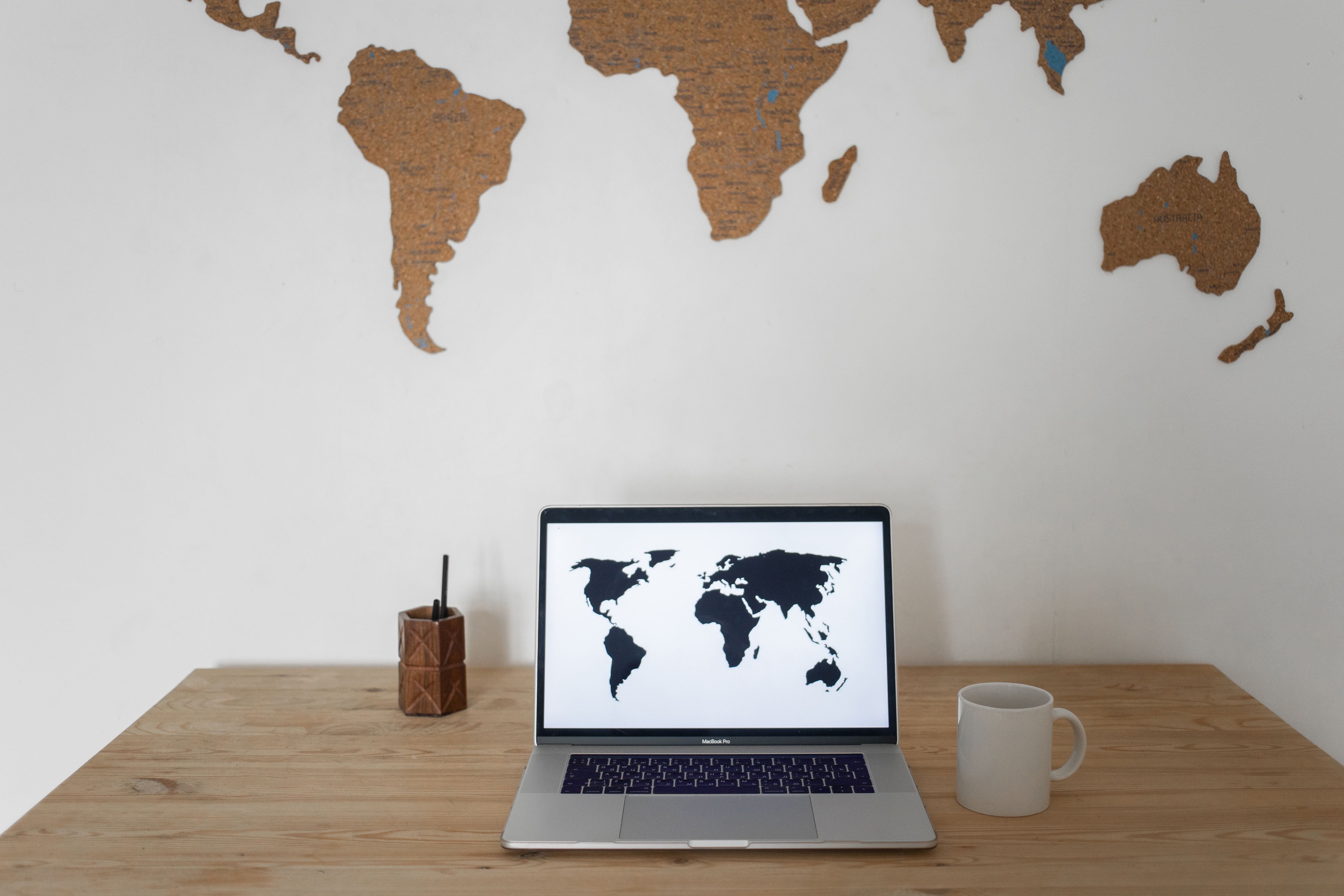World map displayed on a laptop screen symbolizing global connections managed by international law firms