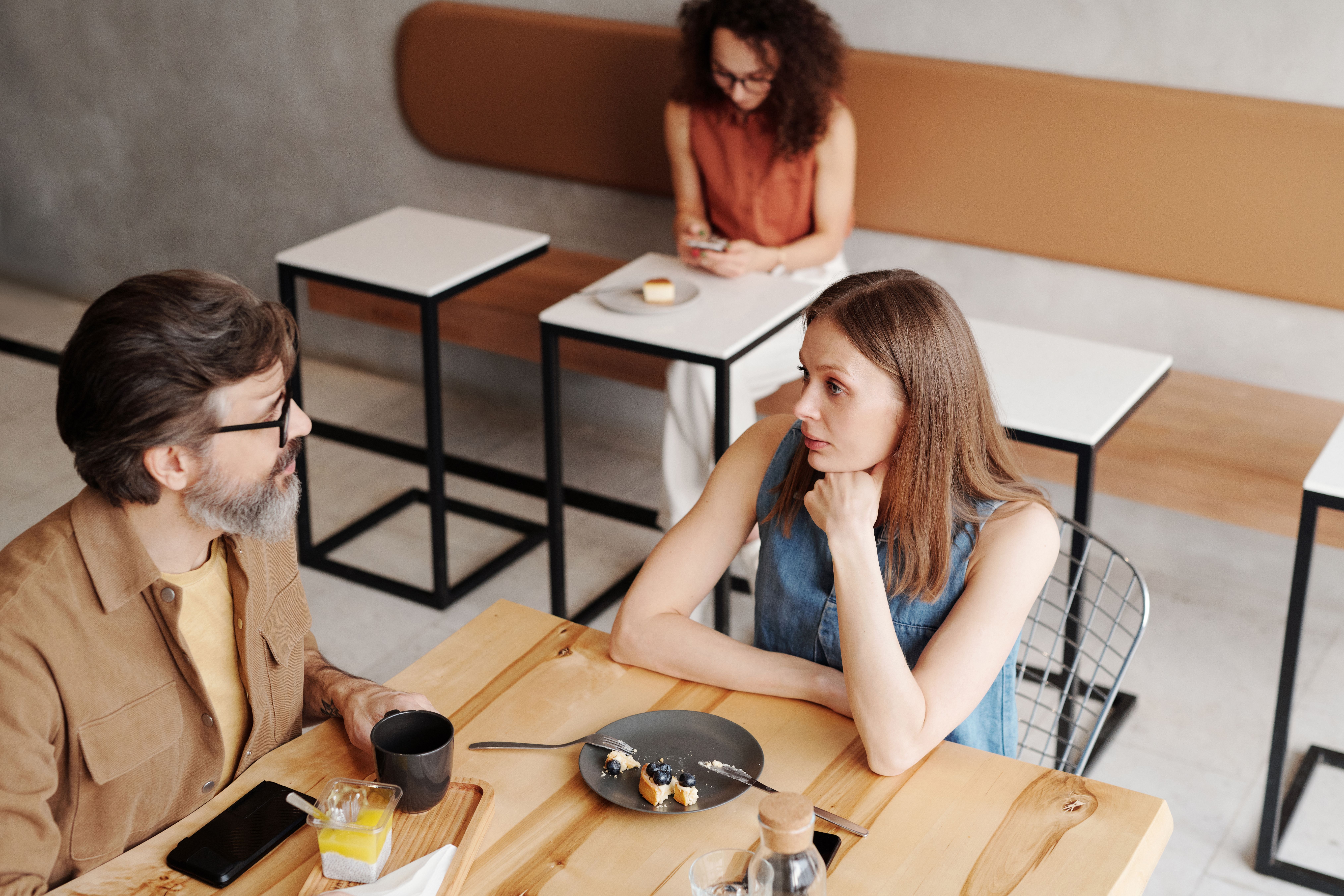 Two people talking over coffee at a cafe, showing the appeal of a relaxed in-person first date.